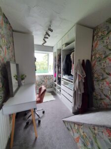 A creative use of a small box room which has been transformed in to a walk in wardrobe and vanity area. It has bold wallpaper and lots of clever storage